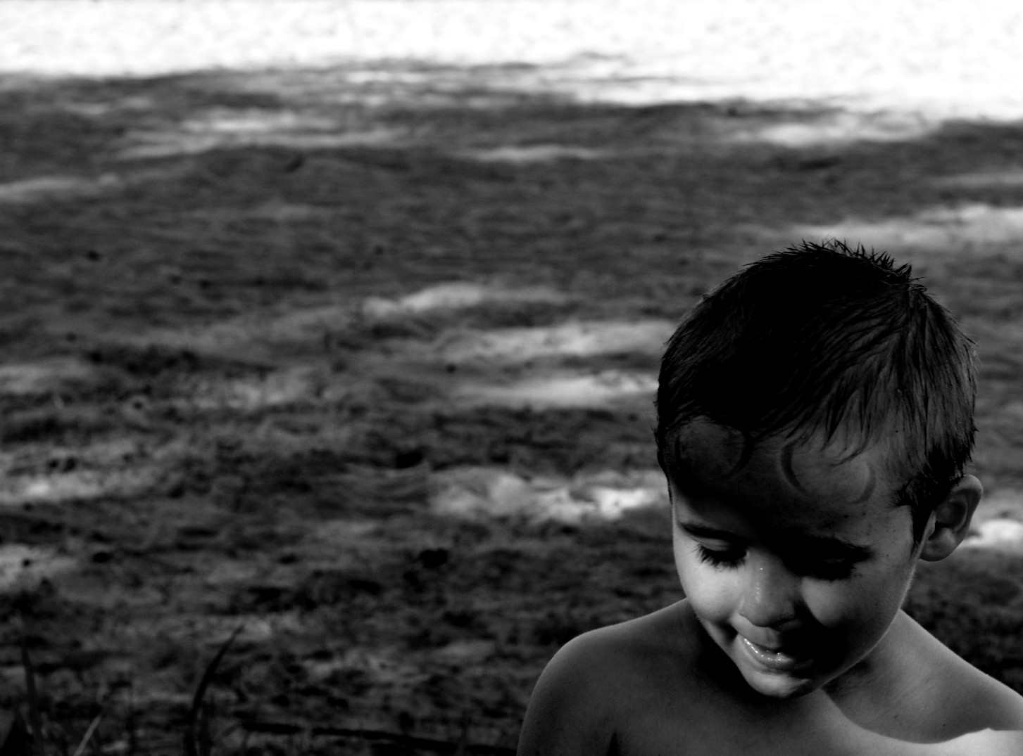 Svartvit pojke på strand