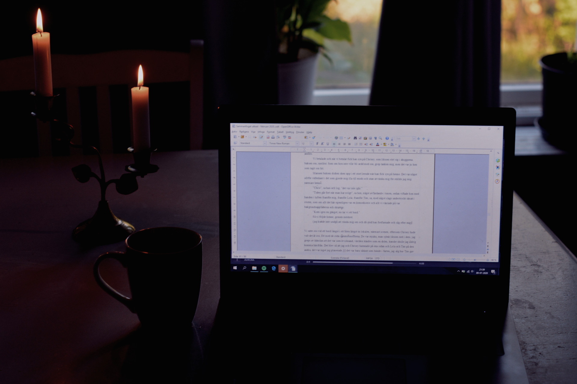 Skriva på en laptop med levande ljus