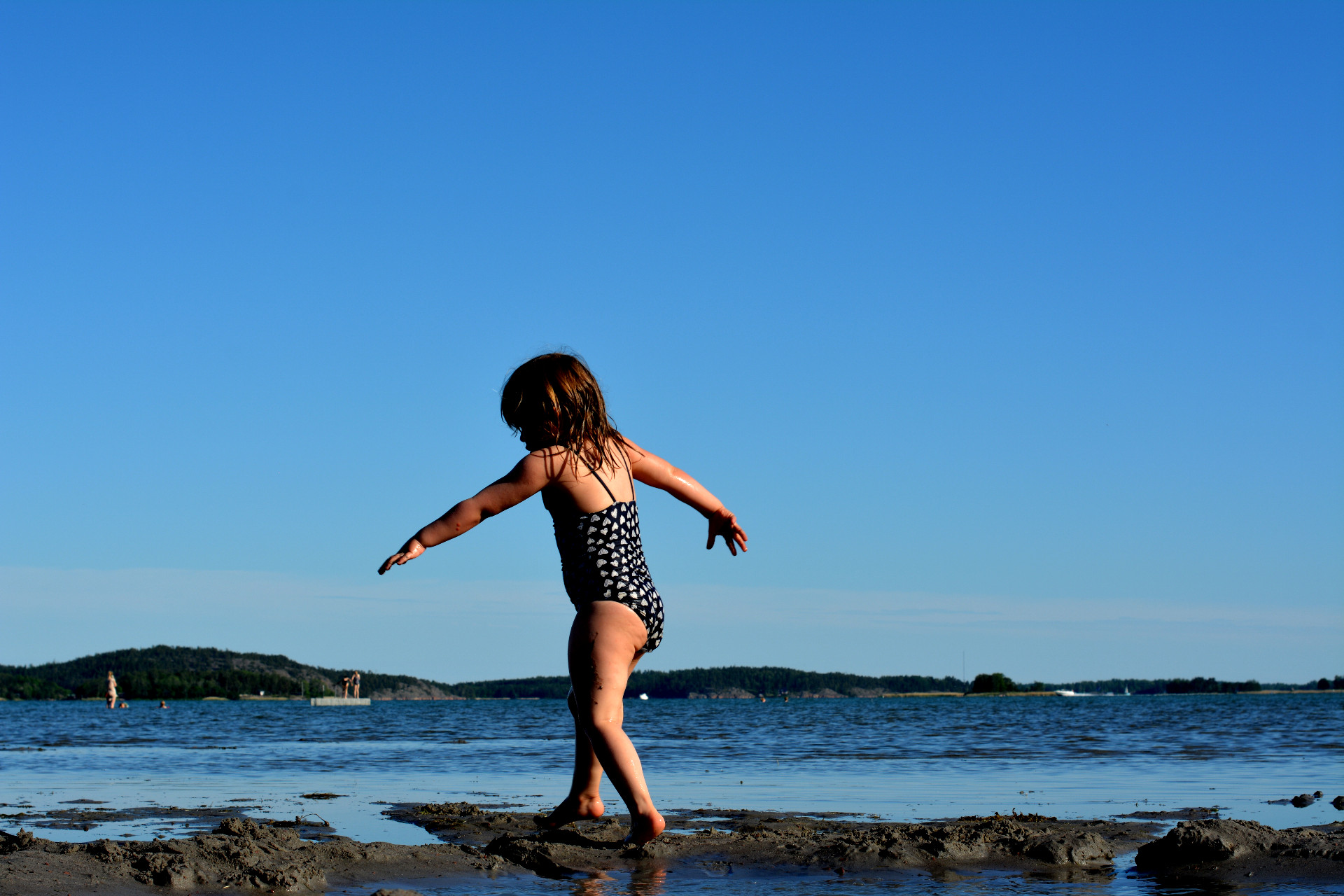 liten flicka promenerar vid havet