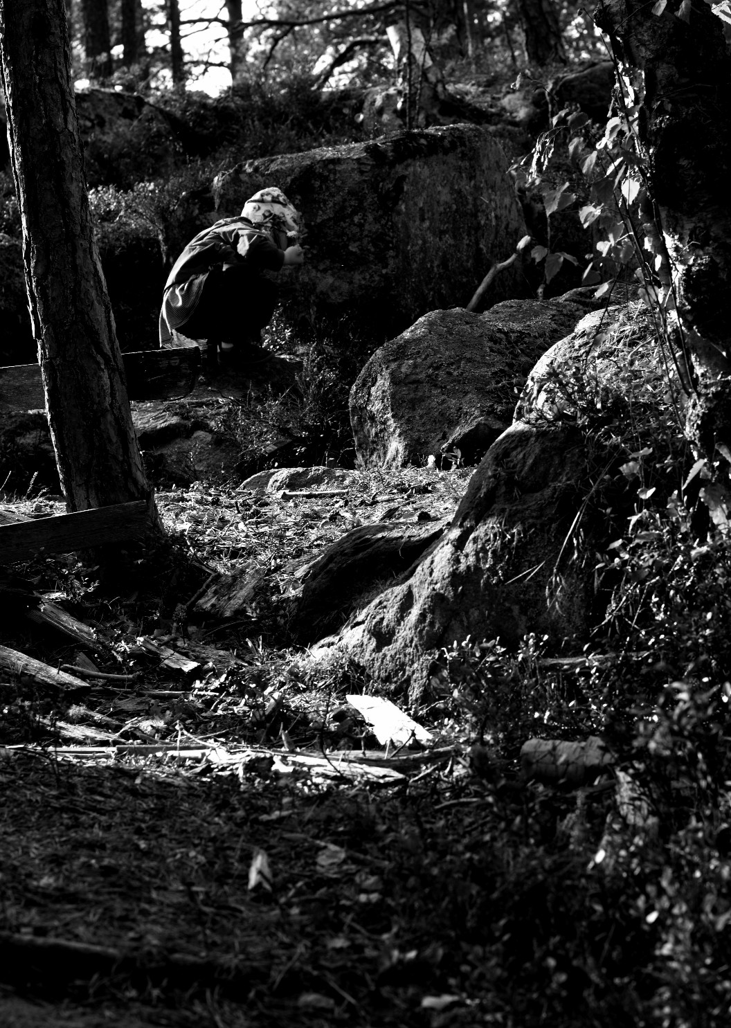 barn på huk i skogen. svartvitt